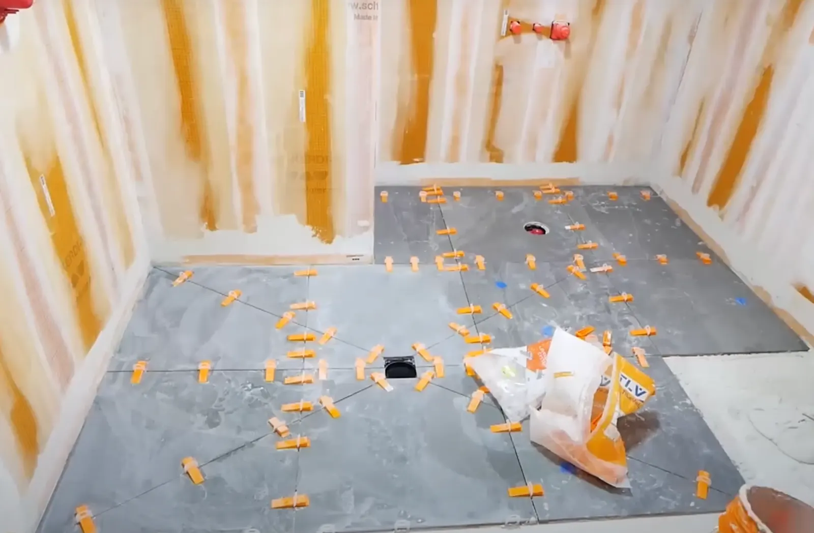 Waterproof membrane and tile leveling clips during a Neptune Beach shower pan build